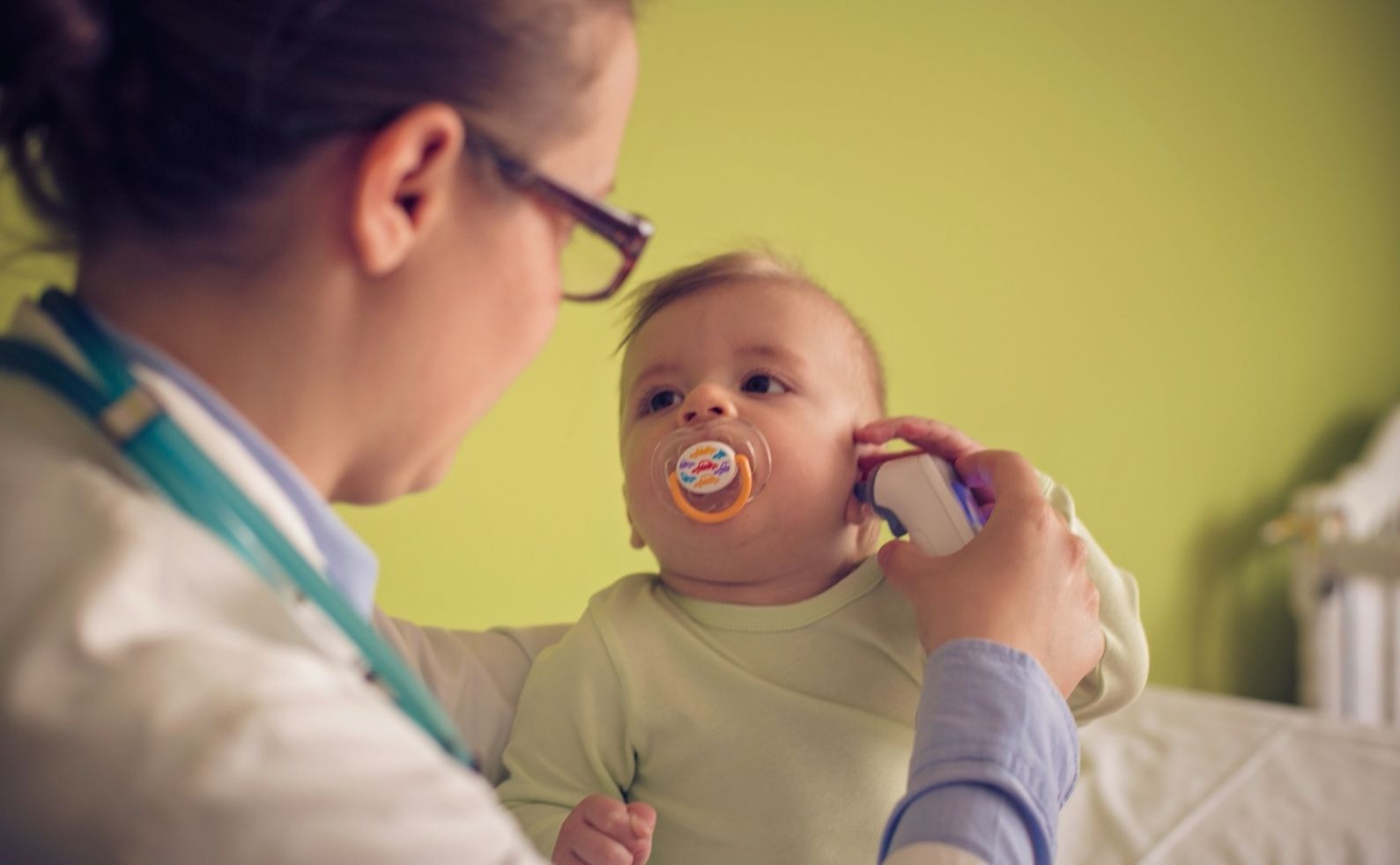 Doctor Checks The Temperature Of A Sick Baby boy at the doctors office
